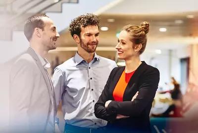 an image of two male coworkers and a female standing and talking