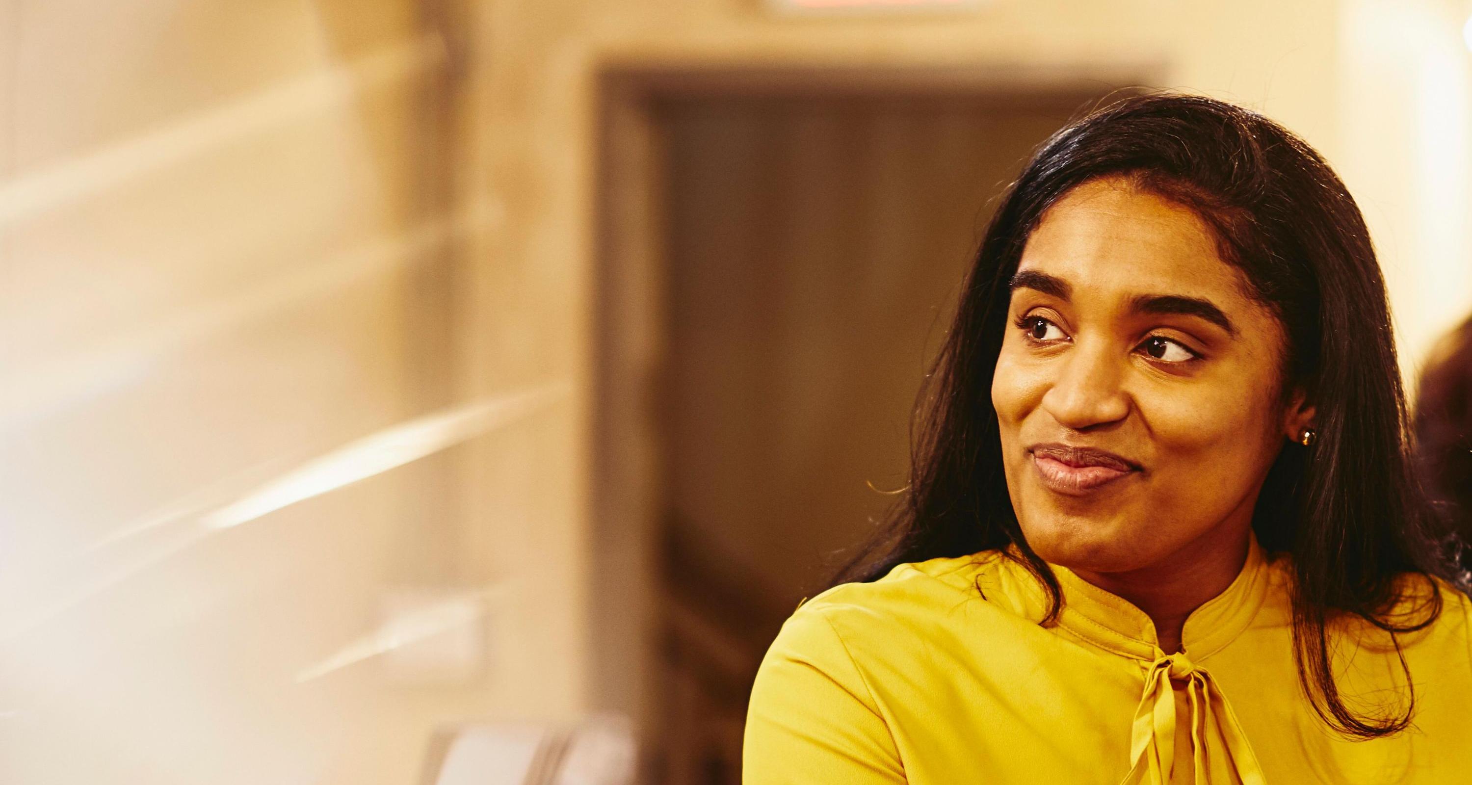 a woman wearing a yellow top smiling