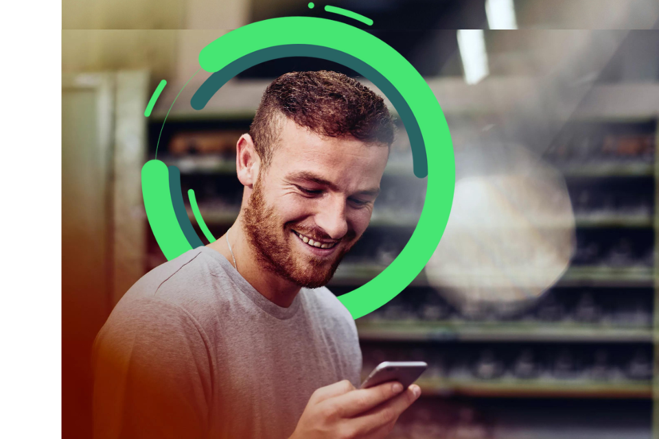 man with a beard on his phone smiling with green circular illustration behind him